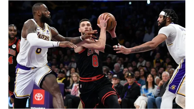 Zach LaVine #8 of the Chicago Bulls drives to the basket in between LeBron James #6 and Anthony Davis #3 of the Los Angeles Lakers
