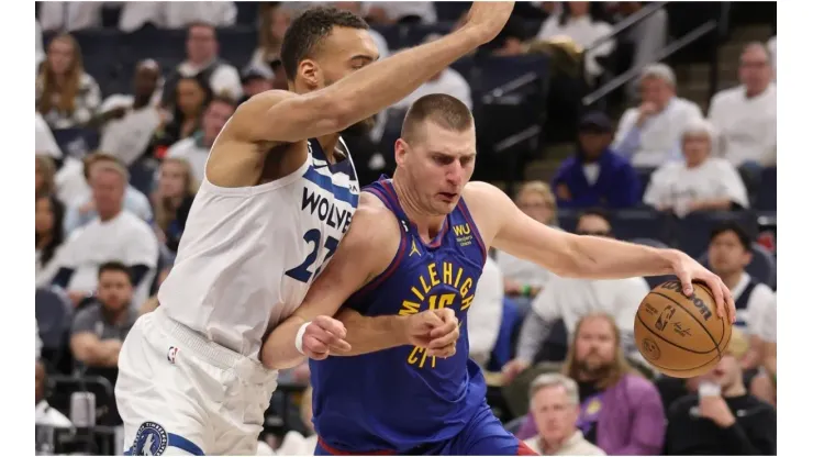 Nikola Jokic #15 of the Denver Nuggets drives around Rudy Gobert #27 of the Minnesota Timberwolves
