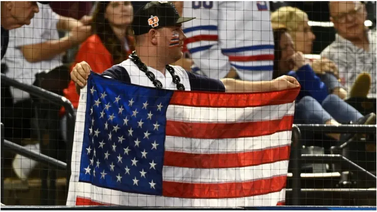 A fan of the United States holds up a flag
