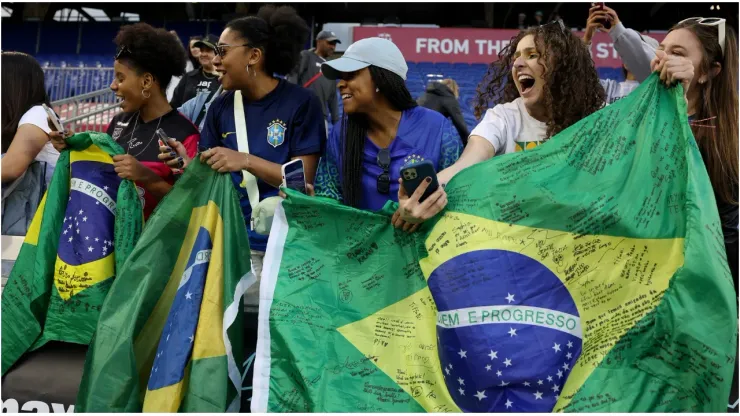 Fans hold Brazil flags
