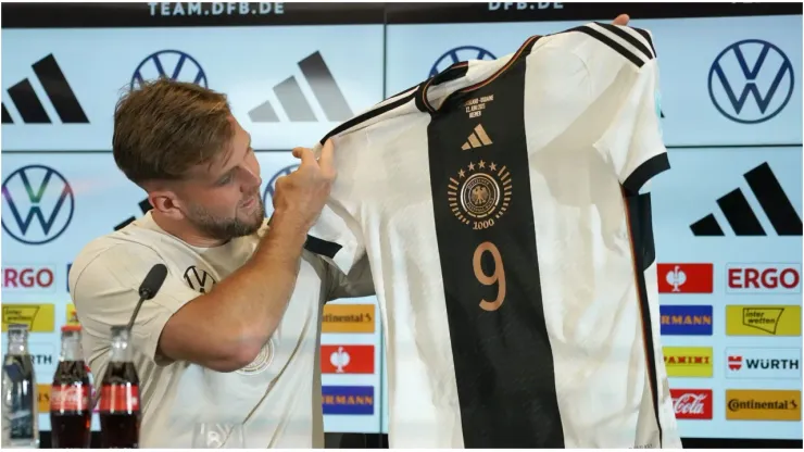 Niclas Fuellkrug holds up a team shirt
