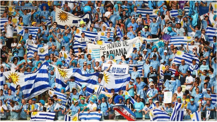 Uruguay fans hold up their country's flags
