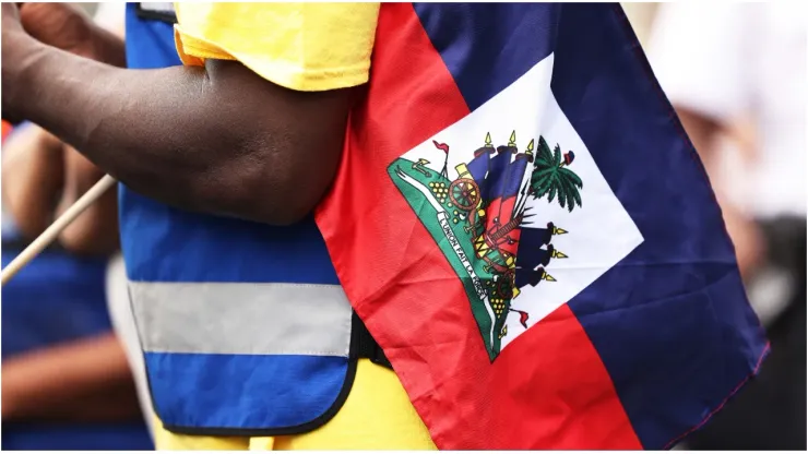 A man holds a Haitian flag
