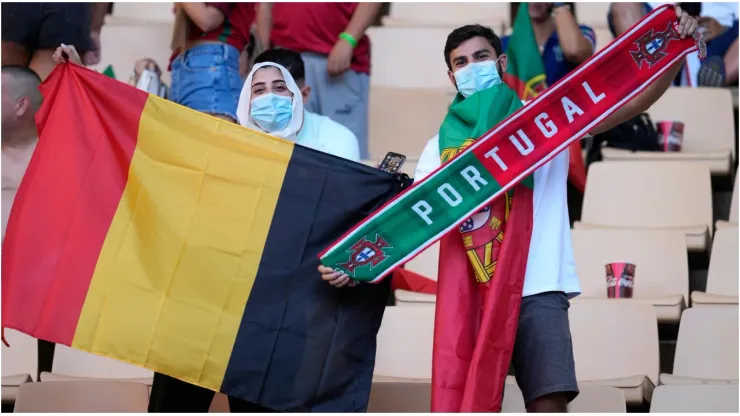 Fans of Belgium and Portugal wave a flag and a scarf
