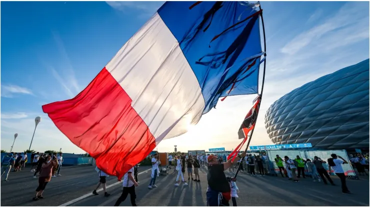 A man carrying a huge French flag
