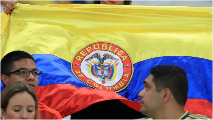 A fan of Colombia shows a Colombian flag
