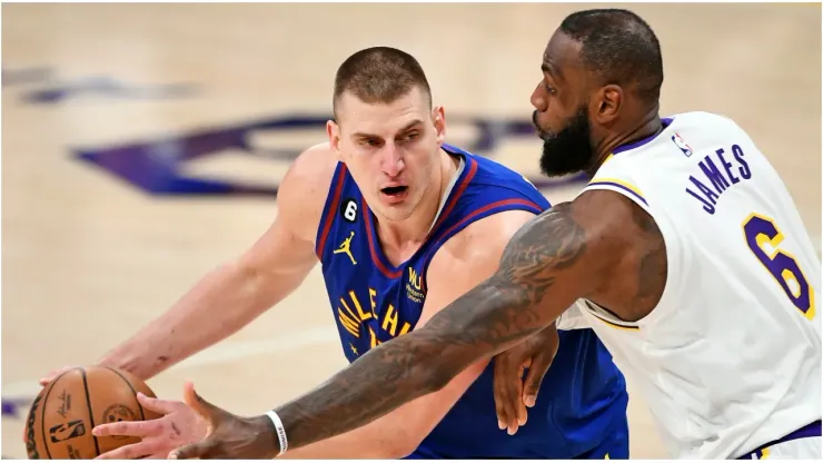 Nikola Jokic #15 of the Denver Nuggets handles the ball against LeBron James #6 of the Los Angeles Lakers
