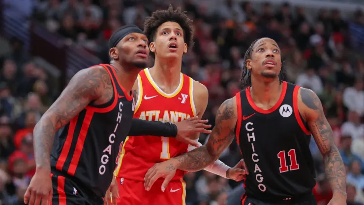 Torrey Craig 13 of the Chicago Bulls and DeMar DeRozan 11 of the Chicago Bulls box out Jalen Johnson 1 of the Atlanta Hawks during the second half at the United Center on April 1, 2024 in Chicago, Illinois.
