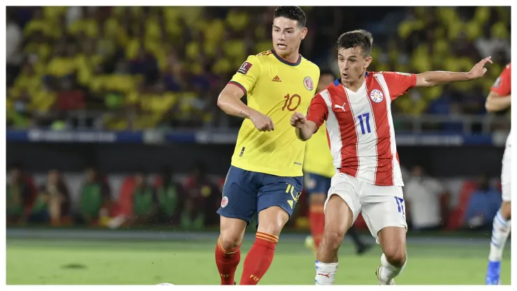 Andres Cubas of Paraguay and James Rodriguez of Colombia fight for the ball during a match
