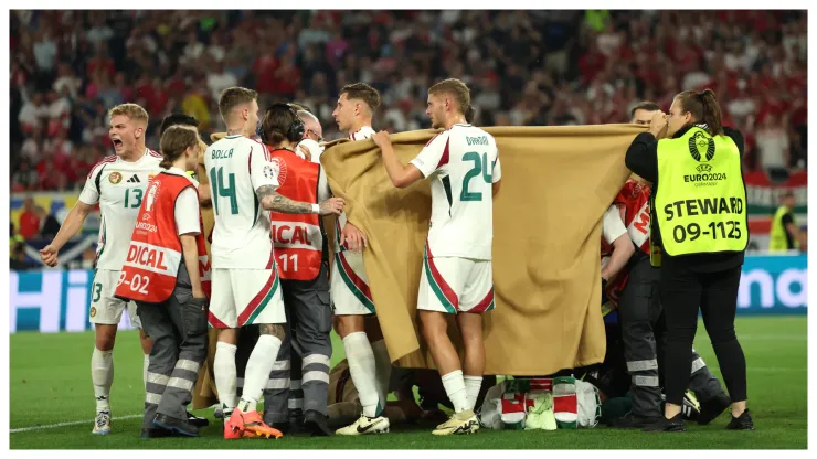 Players of Hungary hold up blankets as they assist medical staff by covering Barnabas Varga of Hungary as he receives medical treatment following a collision with Angus Gunn of Scotland during the UEFA EURO 2024 group stage match.
