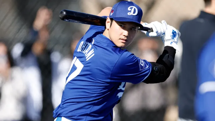 Shohei Ohtani #17 of the Los Angeles Dodgers swings the bat during workouts at Camelback Ranch.
