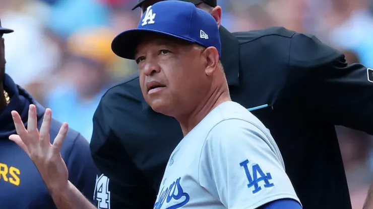 Manager Dave Roberts #30 of the Los Angeles Dodgers speaks with umpires prior to a game against the Milwaukee Brewers at American Family Field.
