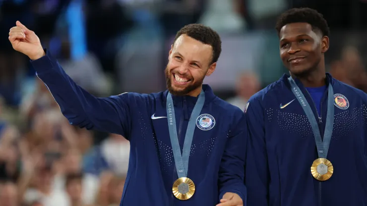 Gold medalists Stephen Curry and Anthony Edwards of Team United States smile on the podium
