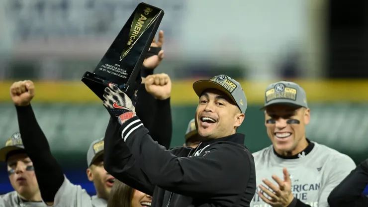 Giancarlo Stanton #27 of the New York Yankees celebrates with the trophy after being named the American League Championship Series MVP after beating the Cleveland Guardians 5-2 in 10 innings in Game Five of the American League Championship Series at Progressive Field on October 19, 2024 in Cleveland, Ohio.
