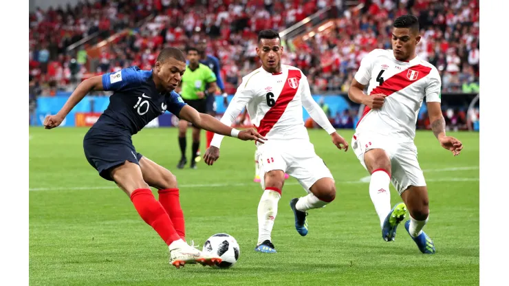 YEKATERINBURG, RUSSIA - JUNE 21:  Kylian Mbappe of France crosses the ball under pressure from Miguel Trauco of Peru and Anderson Santamaria of Peru  during the 2018 FIFA World Cup Russia group C match between France and Peru at Ekaterinburg Arena on June 21, 2018 in Yekaterinburg, Russia.  (Photo by Kevin C. Cox/Getty Images)
