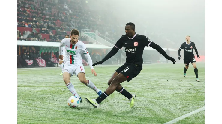 AUGSBURG, GERMANY - DECEMBER 03: William Pacho of Eintracht Frankfurt shoots under pressure from Elvis Rexhbecaj of FC Augsburg  during the Bundesliga match between FC Augsburg and Eintracht Frankfurt at WWK-Arena on December 03, 2023 in Augsburg, Germany. (Photo by Alexander Hassenstein/Getty Images)
