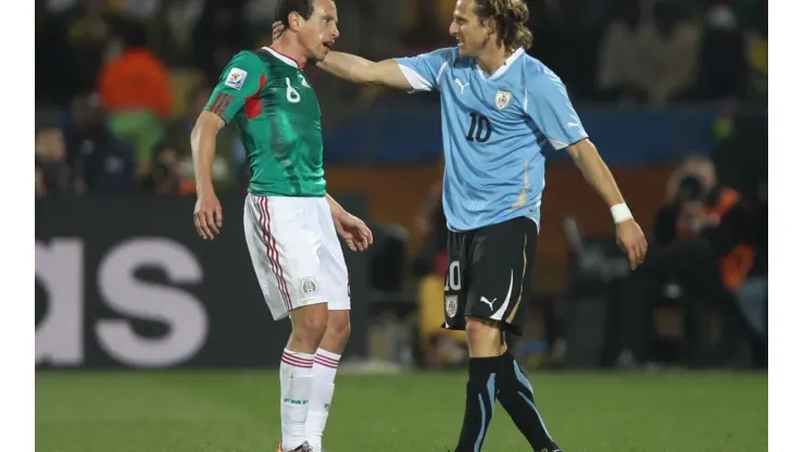 Diego Forlán, de Uruguay, contra Gerardo Torrado, de México, en el Mundial Sudáfrica 2010.
