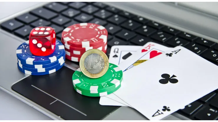 2C6BAH7 Playing cards, casino chips and Euro coin on a laptop keyboard symbolizing online gambling
