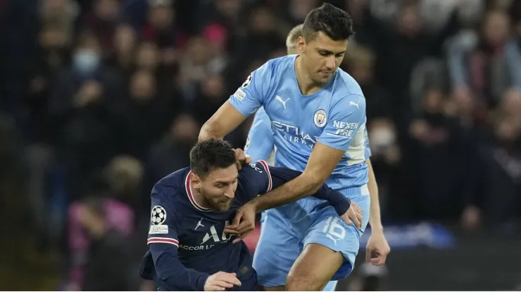 Messi e Rodri disputam a posse de bola.
