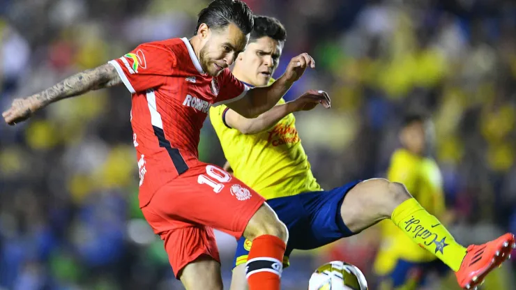 Jesus Angulo (L) of Toluca fights for the ball with Israel Reyes (R) of America.
