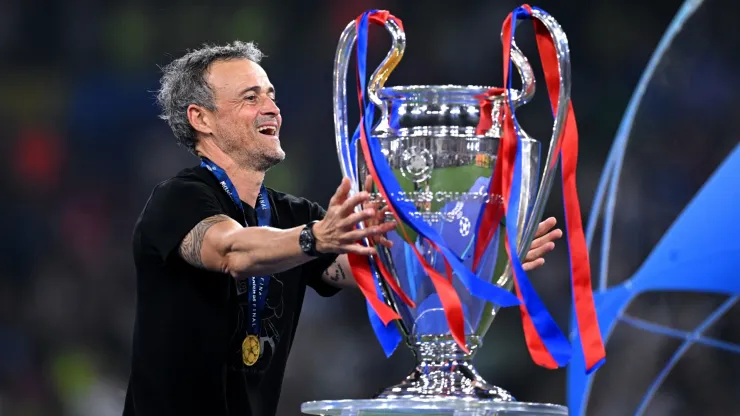 Luis Enrique, Head Coach of Paris Saint-Germain, reacts as he walks past the UEFA Champions League trophy.