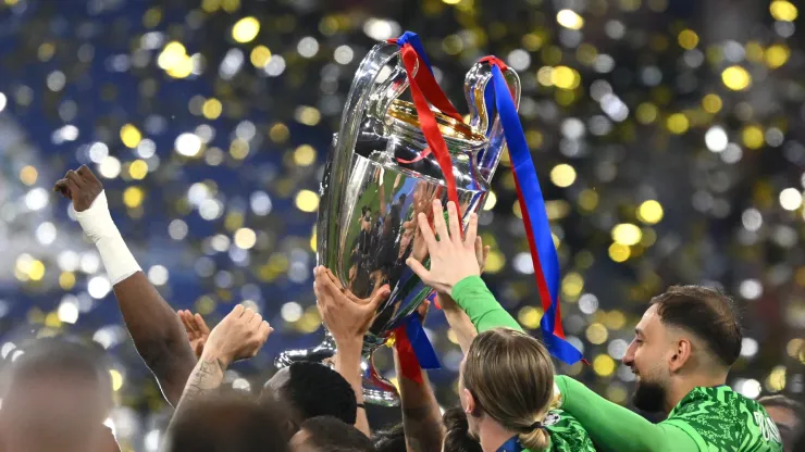The PSG players hold the UEFA Champions League trophy.
