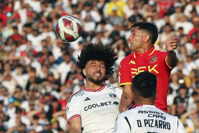 Jonathan Villagra en acción ante Maximiliano Falcón, quien podría ser su compañero de zaga. (Jonnathan Oyarzun/Photosport).