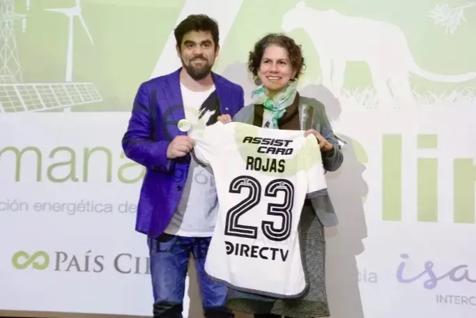 Samuel Pérez, el gerente comercial de Blanco y Negro, le entrega una camiseta a la ministra Maisa Rojas durante la cita en la COP 16