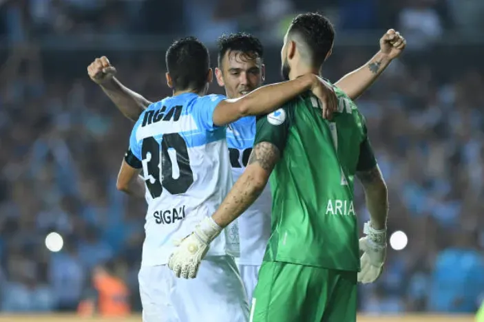 Leonardo Sigali, Gabriel Arias y Nery Domínguez se funden en un abrazo por un triunfo de Racing Club. (Getty Images).