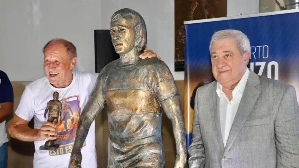 Roberto Mouzo, junto a su estatua en el club (X @BocaJrsOficial).