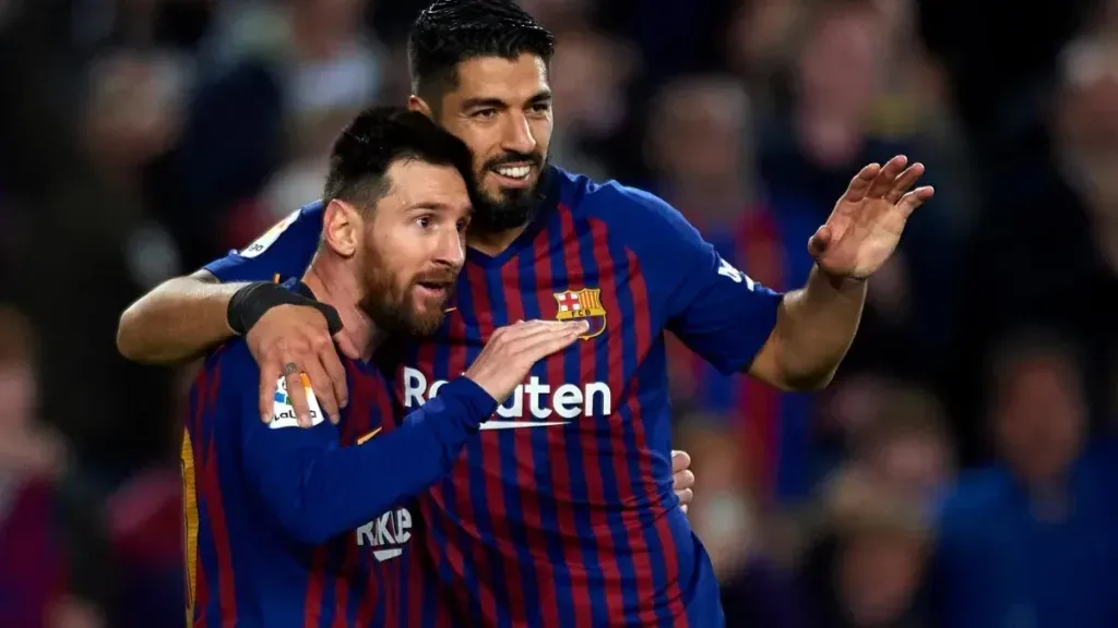 Foto: Quality Sport Images/Getty Images – Lionel Messi e Luis Suárez se abraçando durante partida pelo Barcelona.