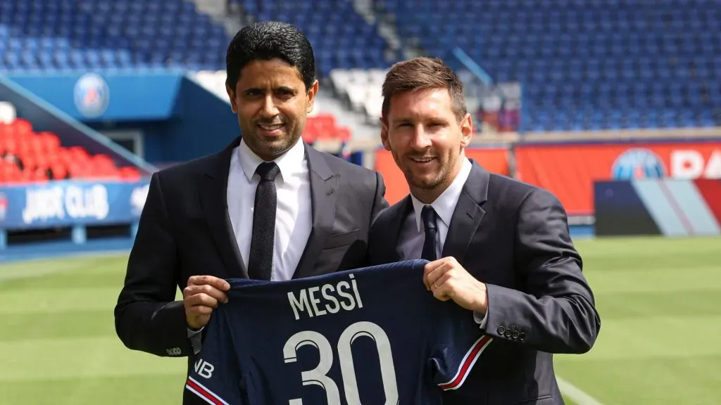 Lionel Messi poses with his jersey next to President Nasser Al Khelaifi after the press conference of Paris Saint-Germain at Parc des Princes on August 11, 2021 in Paris, France.