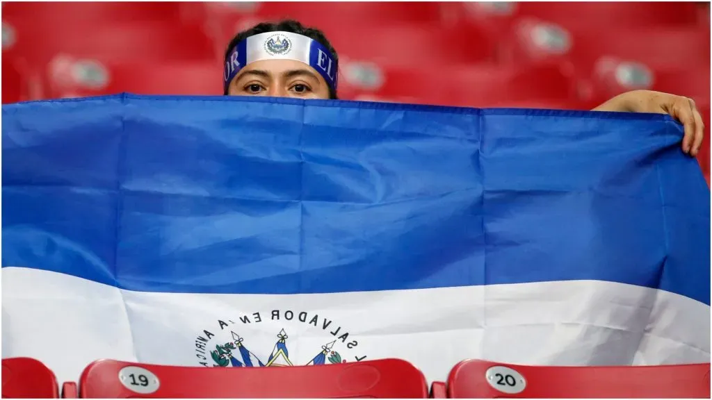 An El Salvador soccer fan peers from behind the country’s national flag – Ralph Freso/Getty Images