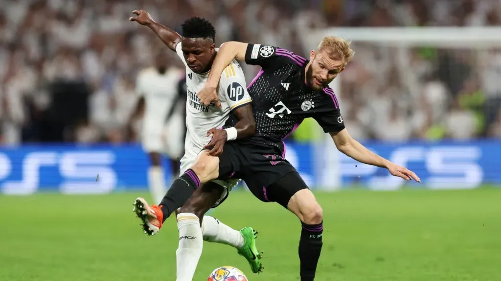 Vinicius Junior of Real Madrid is challenged by Konrad Laimer of Bayern Munich during the UEFA Champions League semi-final second leg match between Real Madrid and FC Bayern München at Estadio Santiago Bernabeu on May 08, 2024 in Madrid, Spain.