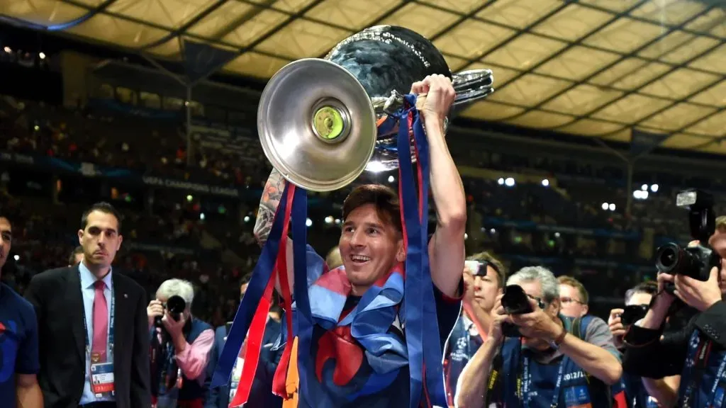Lionel Messi of Barcelona celebrates with the trophy watched by Luis Suarez after the UEFA Champions League Final between Juventus and FC Barcelona at Olympiastadion on June 6, 2015 in Berlin, Germany.