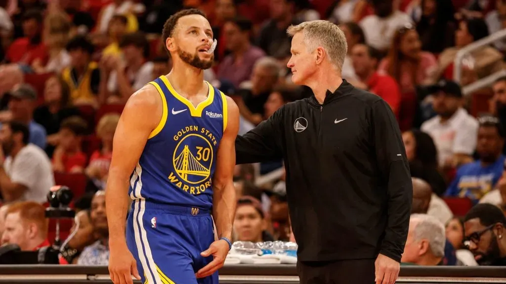 Steve Kerr of the Golden State Warriors greets Stephen Curry during a game.
