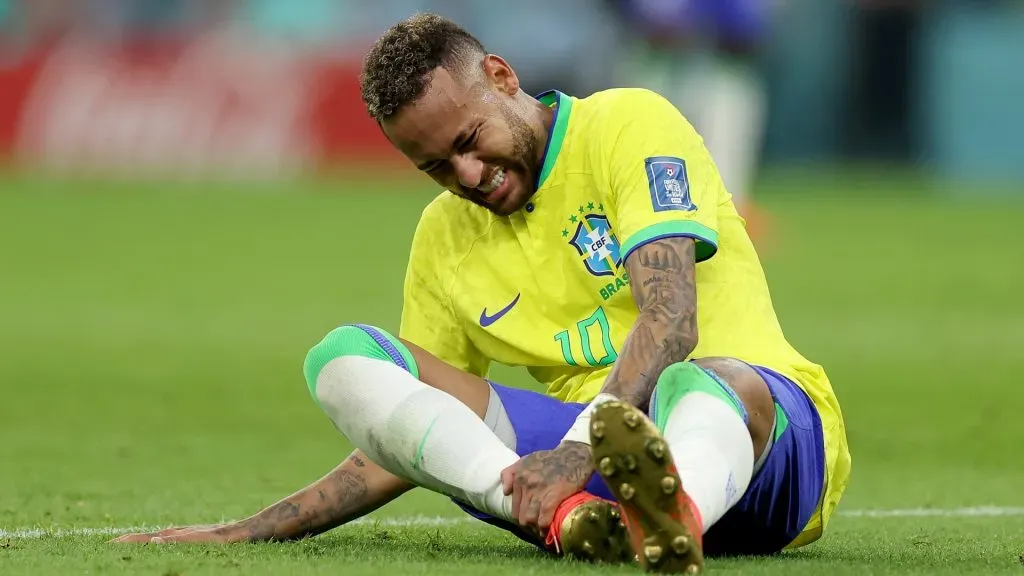 Neymar of Brazil sits injured on the pitch during the FIFA World Cup Qatar 2022. Photo by Lars Baron/Getty Images.