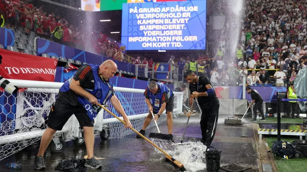 Ground staff attempt to clear excess water as play is suspended due to adverse weather conditions during the UEFA EURO 2024 round of 16 match between Germany and Denmark at Football Stadium Dortmund on June 29, 2024 in Dortmund, Germany. Photo by Dean Mouhtaropoulos/Getty Images