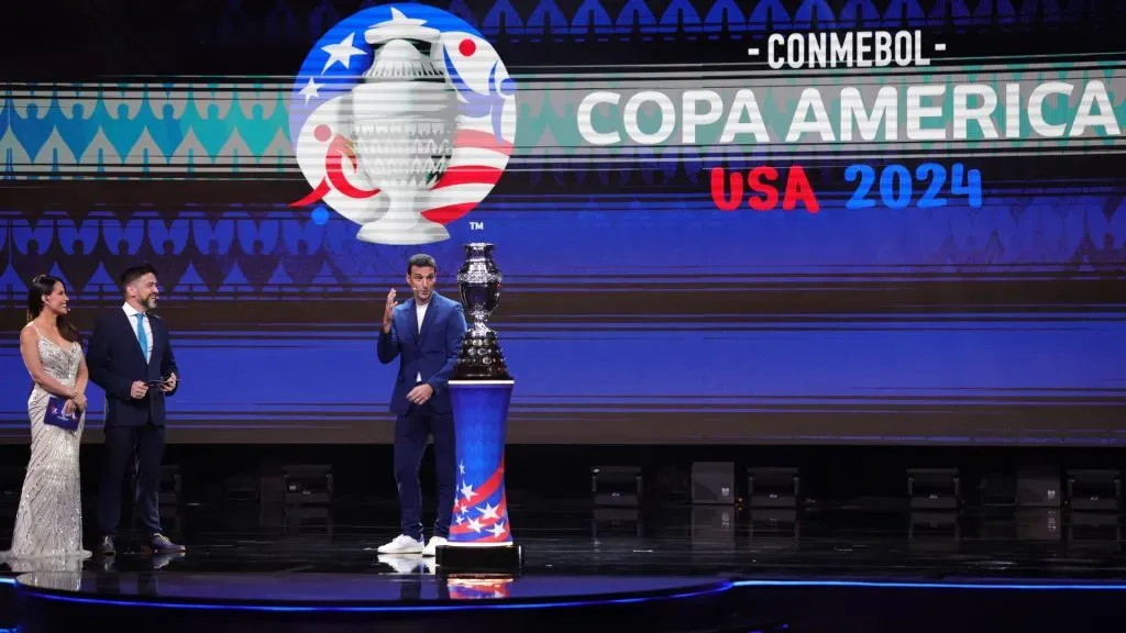 Lionel Scaloni, Head Coach of Argentina, talks to presenters Lindsay Casinelli and Juan Jose Buscalia with the trophy during the official draw of CONMEBOL Copa America 2024 at James L. Knight Center on December 07, 2023 in Miami, Florida. Photo by Megan Briggs/Getty Images