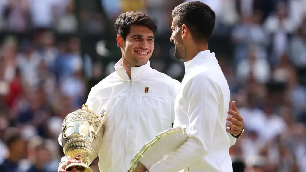 Carlos Alcaraz of Spain holds the Gentlemen’s Singles Trophy while he talks to Novak Djokovic of Serbia as he holds his Runner-Up Trophy following the Gentlemen’s Singles Final during day fourteen of The Championships Wimbledon 2024 at All England Lawn Tennis and Croquet Club on July 14, 2024 in London, England. Photo by Julian Finney/Getty Images