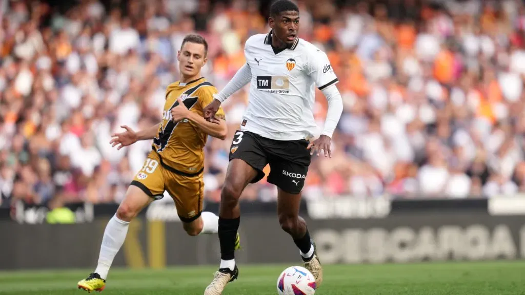 Cristhian Mosquera of Valencia CF runs with the ball whilst under pressure from Jorge De Frutos of Rayo Vallecano during the LaLiga EA Sports match between Valencia CF and Rayo Vallecano. Alex Caparros/Getty Images