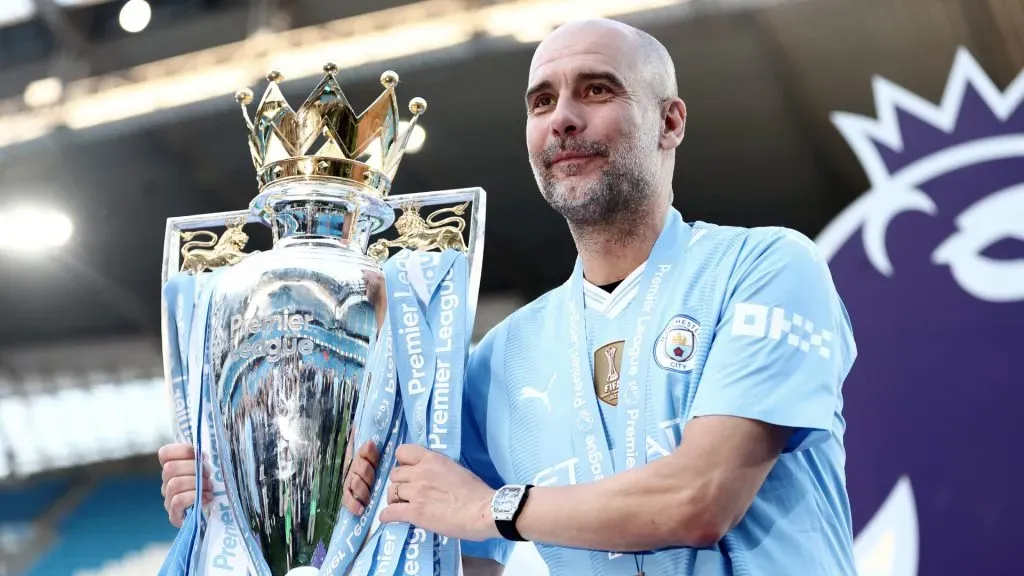 Pep Guardiola, Manager of Manchester City, poses for a photo with the Premier League title trophy following their teams victory during the Premier League match between Manchester City and West Ham. Naomi Baker/Getty Images
