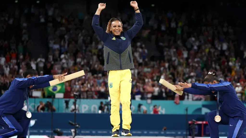 Gold medalist Rebeca Andrade (C) of Team Brazil, silver medalist Simone Biles (L) of Team United States and bronze medalist Jordan Chiles (R) of Team United States celebrate on the podium. Naomi Baker/Getty Images