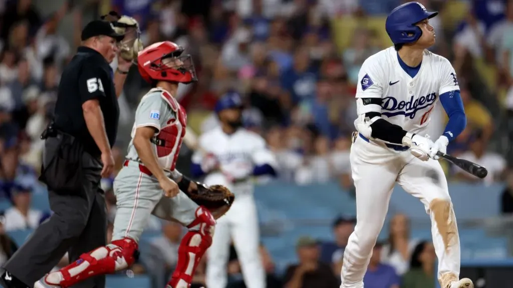 Shohei Ohtani #17 of the Los Angeles Dodgers watches his solo home run with Garrett Stubbs #21 of the Philadelphia Phillies, to take a 5-3 lead, during the eighth inning at Dodger Stadium on August 05, 2024 in Los Angeles, California. (Photo by Harry How/Getty Images)