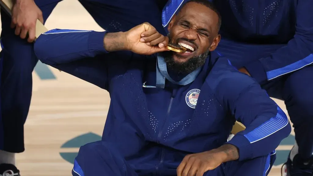 Gold medalist LeBron James of Team United States bites his medal while posing for a photo during the Men’s basketball medal ceremony on day fifteen of the Olympic Games Paris 2024 at Bercy Arena on August 10, 2024 in Paris, France.