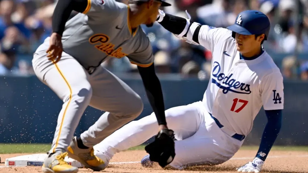 Shohei Ohtani #17 of the Los Angeles Dodgers is safe at third base with a triple ahead of the tag by Ke’Bryan Hayes #13 of the Pittsburgh Pirates in the sixth inning at Dodger Stadium on August 11, 2024 in Los Angeles, California. (Photo by John McCoy/Getty Images)