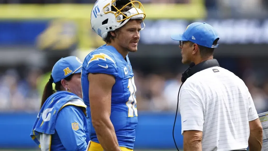 Justin Herbert #10 of the Los Angeles Chargers talks to head coach Jim Harbaugh