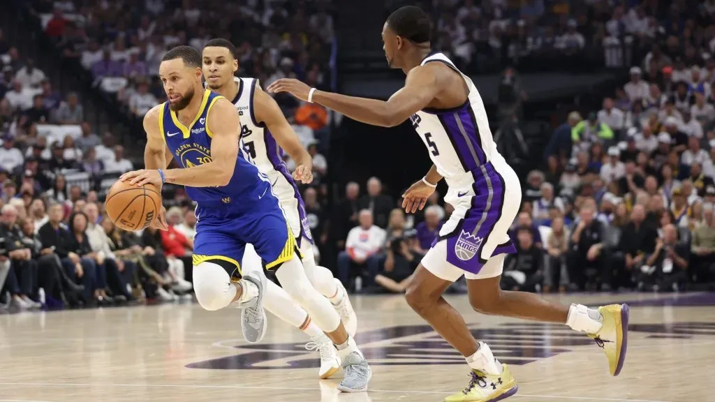 Stephen Curry #30 of the Golden State Warriors is guarded by Keegan Murray #13 and De’Aaron Fox #5 of the Sacramento Kings in the first quarter during the Play-In Tournament at Golden 1 Center on April 16, 2024 in Sacramento, California. (Photo by Ezra Shaw/Getty Images)