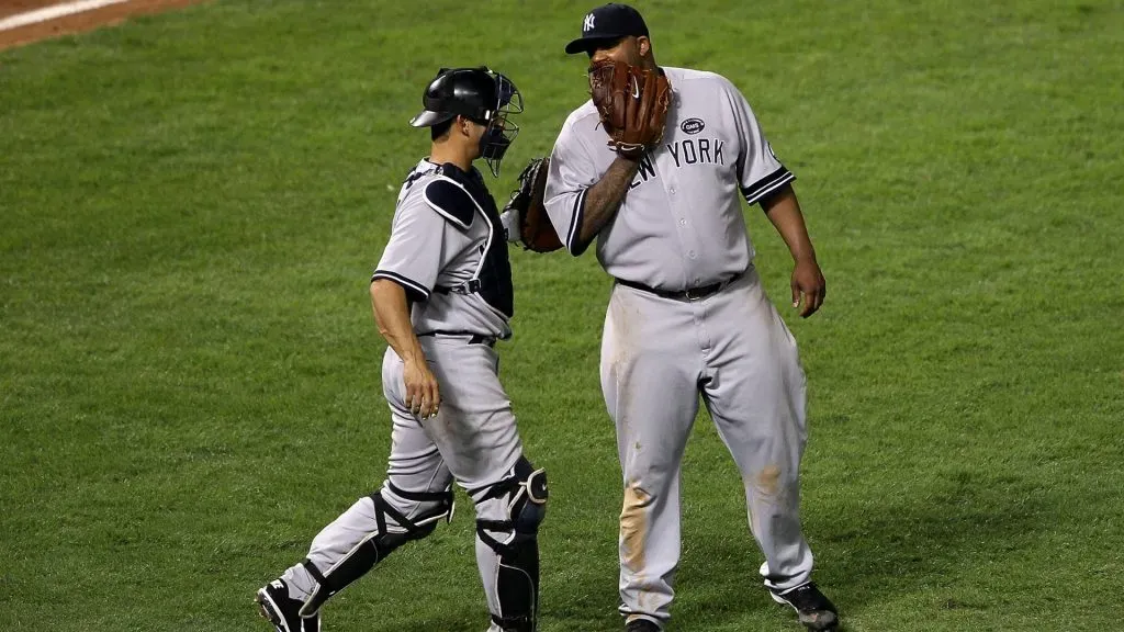 (L-R) Catcher Jorge Posada #20 and CC Sabathia #52 of the New York Yankees talk against the Texas Rangers in Game One of the ALCS during the 2010 MLB Playoffs at Rangers Ballpark in Arlington on October 15, 2010 in Arlington, Texas. (Photo by Elsa/Getty Images)