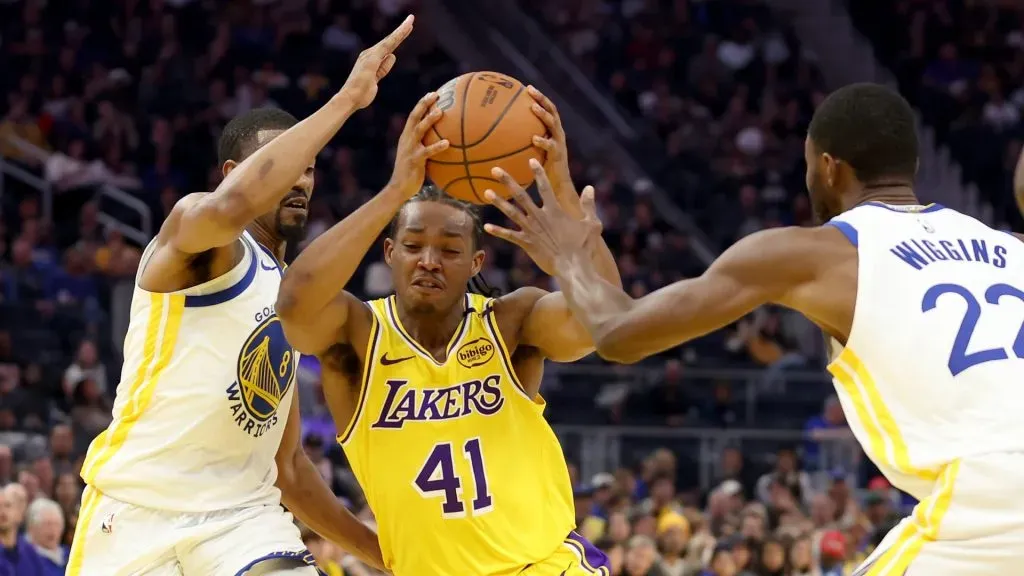 Quincy Olivari #41 of the Los Angeles Lakers is guarded by De’Anthony Melton #8 and Andrew Wiggins #22 of the Golden State Warriors during the first half of their preseason game at Chase Center on October 18, 2024 in San Francisco, California. (Photo by Ezra Shaw/Getty Images)